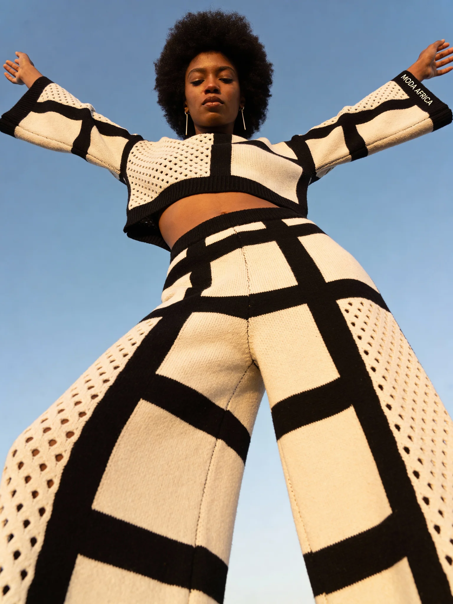 Fashion black woman in black and white geometric knit set outdoors